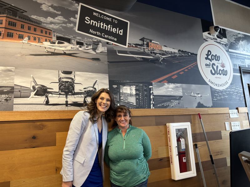 Caitlin with a resident in front of a Welcome to Smithfield, North Carolina mural